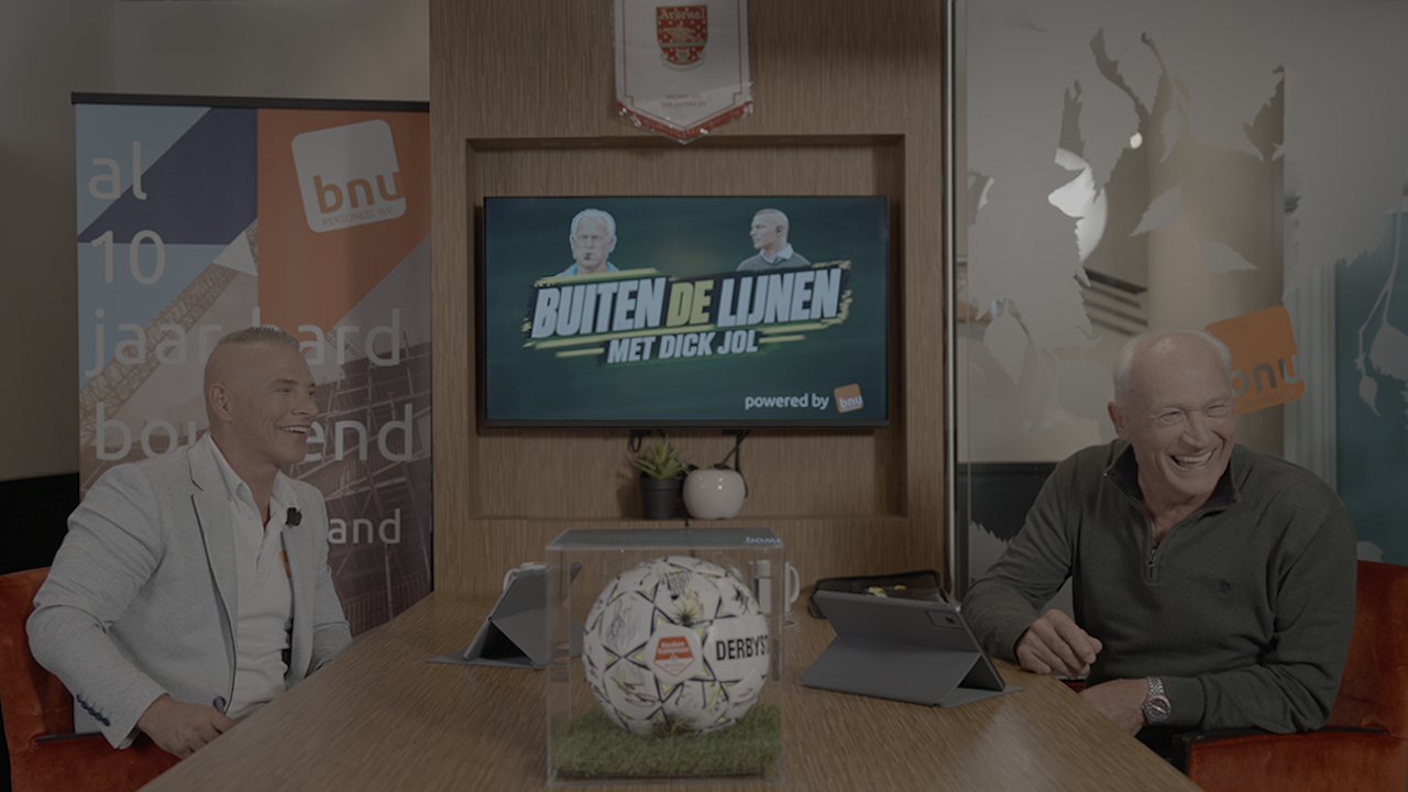 Marco Saat en Dick Jol lachend aan tafel in de studio van Buiten de Lijnen